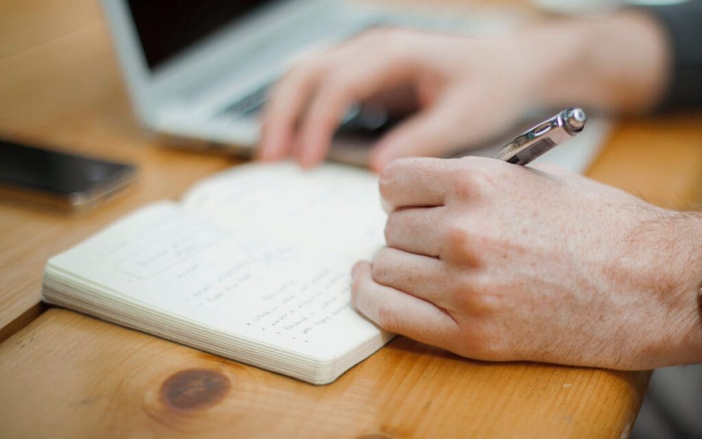 person writing in notebook