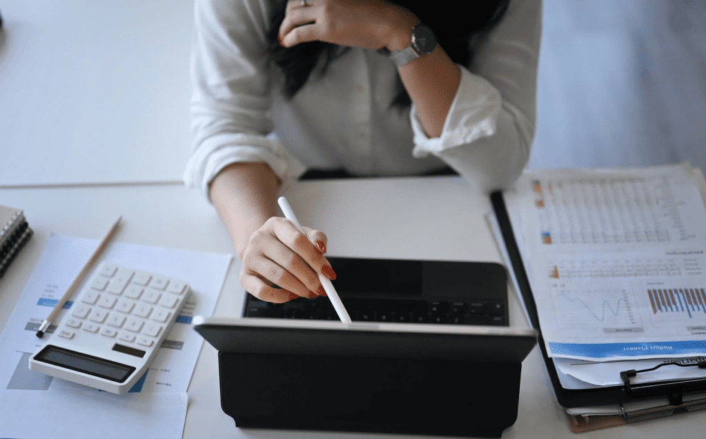 person pointing at a laptop with a pen